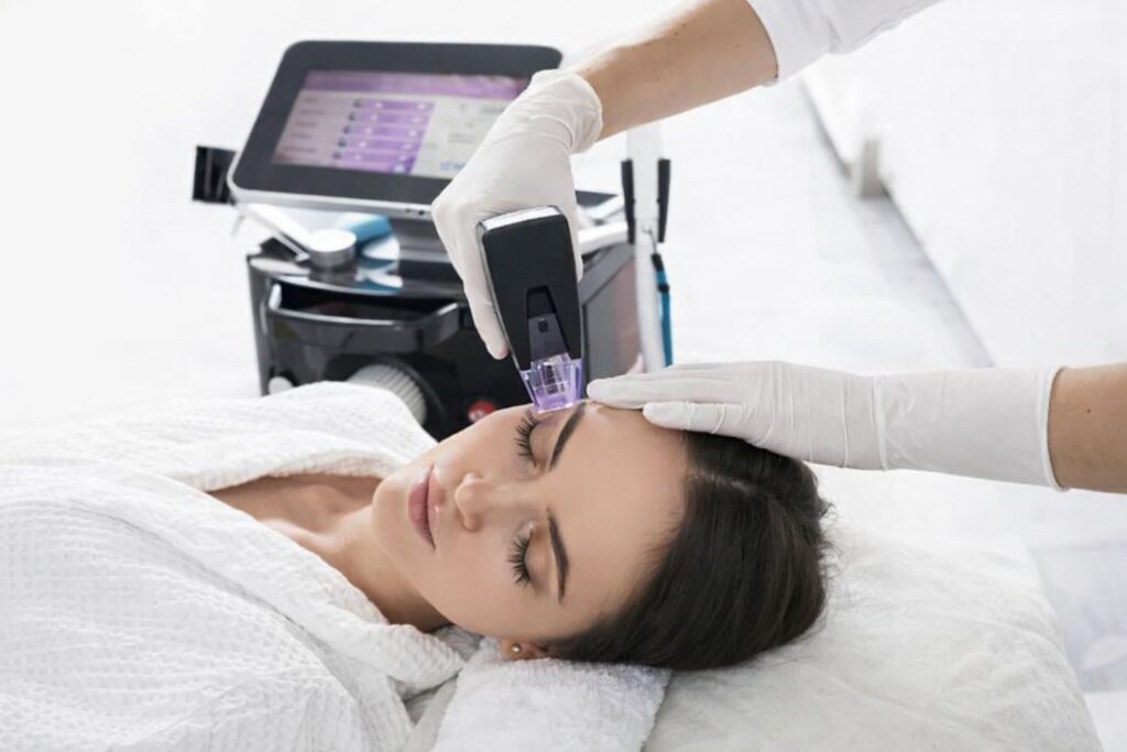 Advanced facial skin treatment using aesthetic device on forehead for smoother and glowing skin