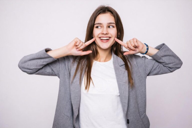 Young woman smiling and highlighting her teeth after dental facial rejuvenation treatment that improves smile balance and overall facial appearance.
